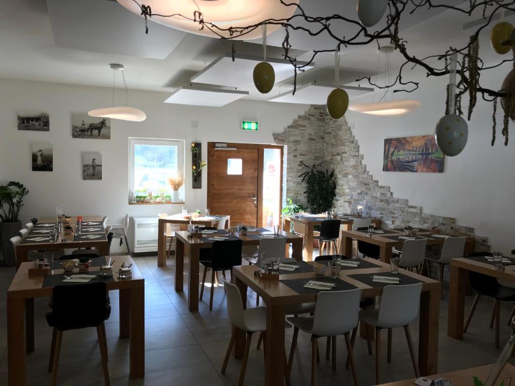 un ristorante con tavoli e sedie in legno e un muro di pietra di Agriturismo Regusci a Camorino