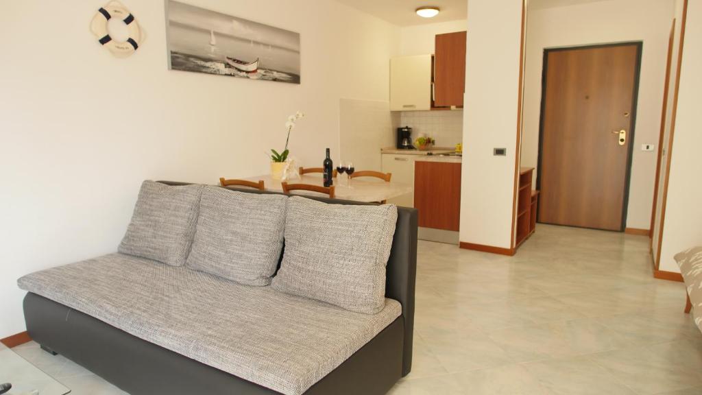 een woonkamer met een bank en een keuken bij Studio apartman Erika in Ližnjan
