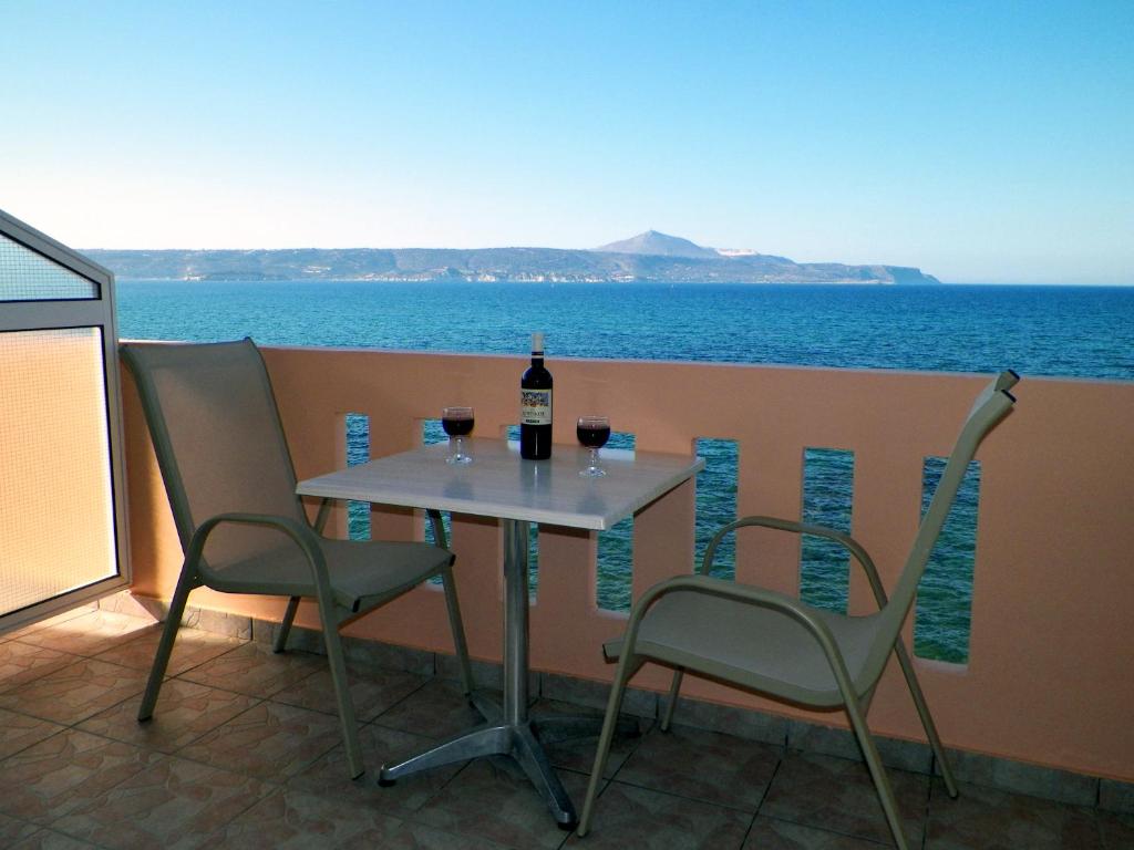 una mesa con 2 sillas y una botella de vino en Christi Apartments, en Kalyves