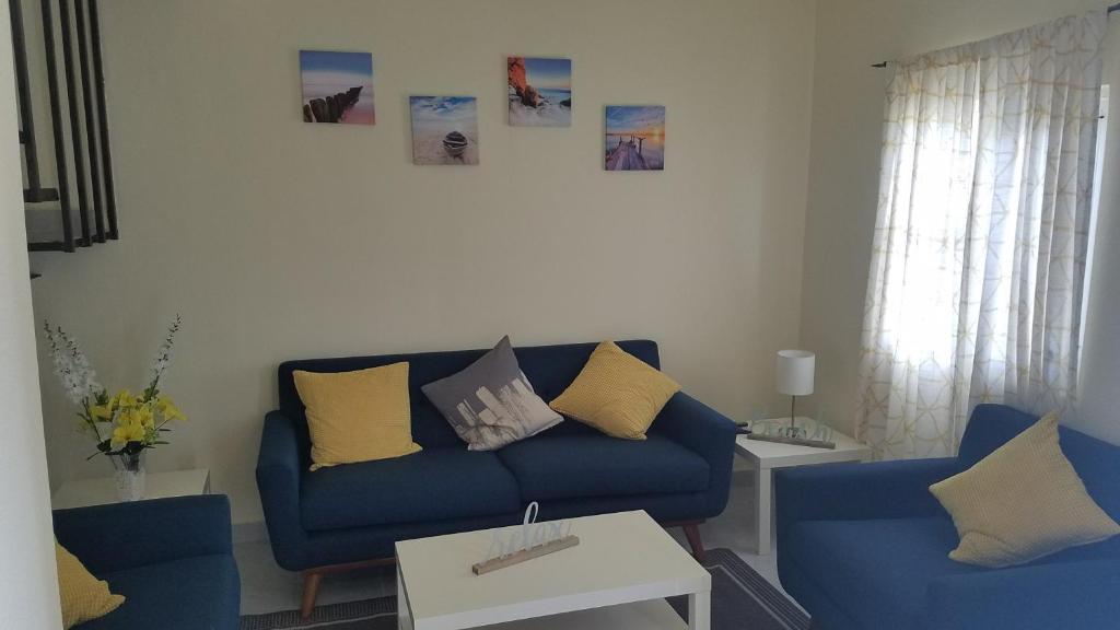 a living room with a blue couch and two chairs at villa serena 4 Beds, 2 Bath in Rosarito