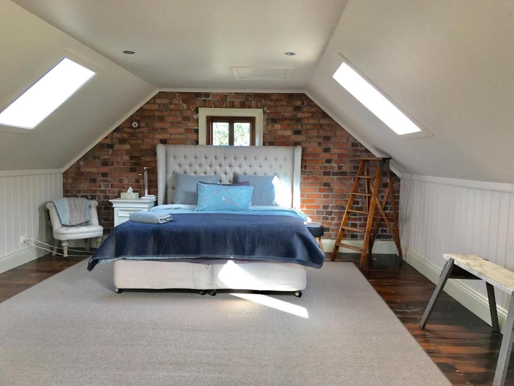 a bedroom with a bed and a brick wall at Robin Hoods Well Farm Stay in Sassafras