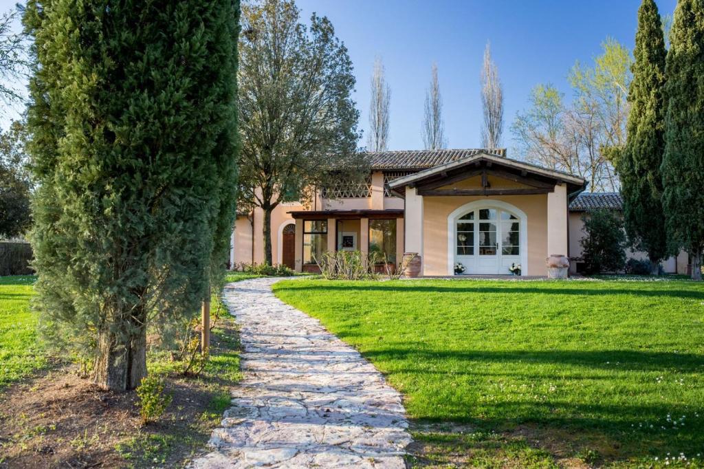 a house with a pathway in front of a yard at Hotel Villaggio Le Stelline in Montefalco