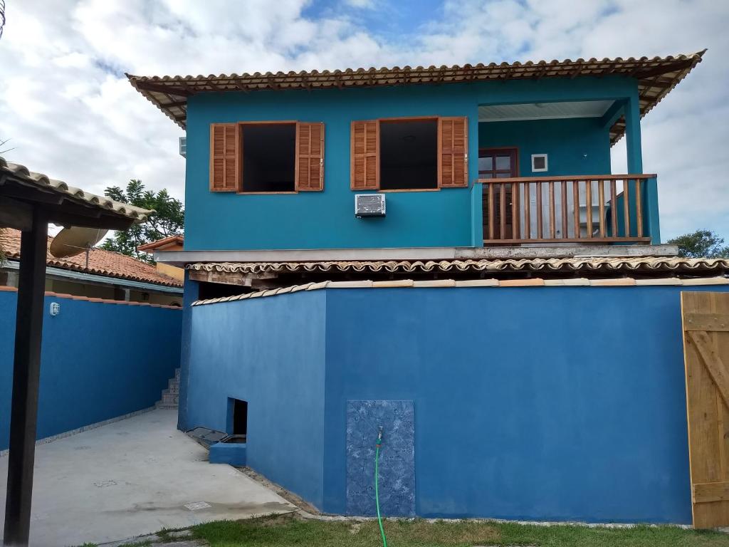 Casa temporada em Búzios, bairro residencial familiar في بوزيوس: البيت الأزرق مع شرفة