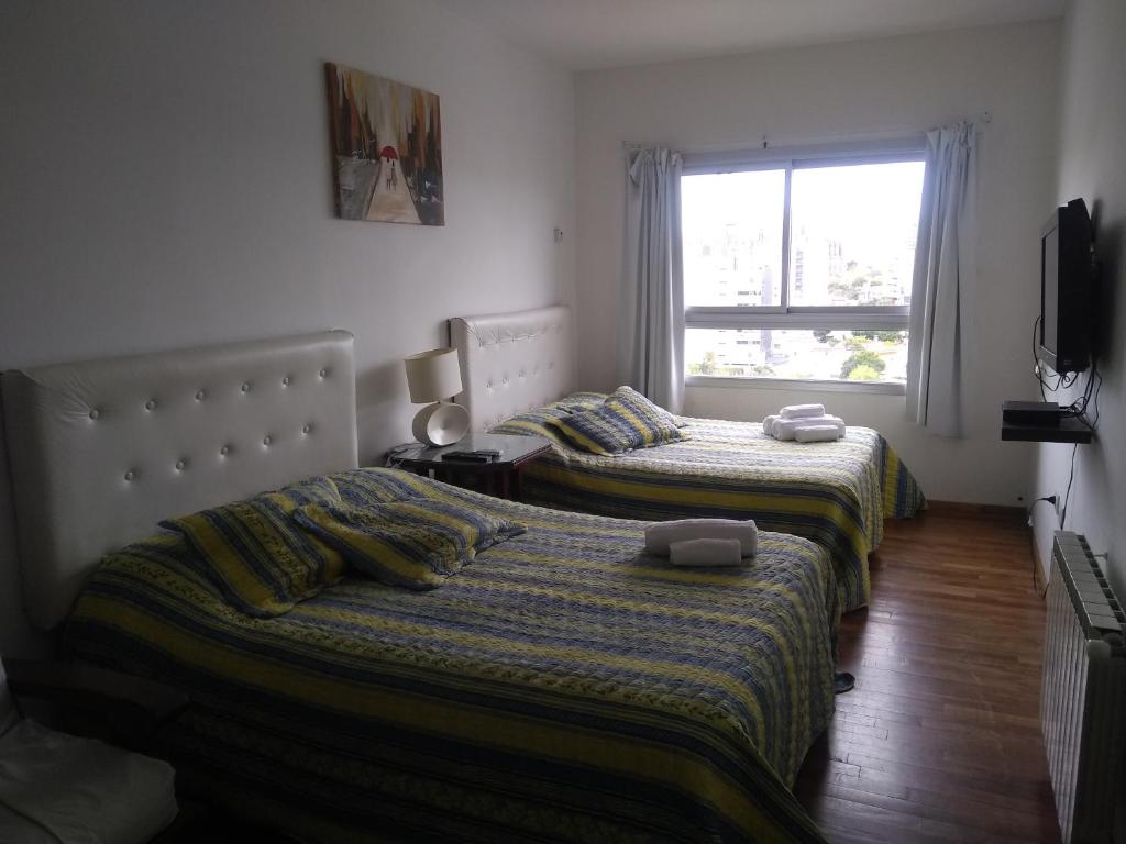 1 dormitorio con 2 camas y ventana en Temporario 44 en La Plata