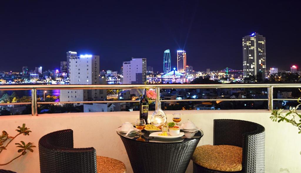 a table on a balcony with a view of the city at D&C Hotel in Danang