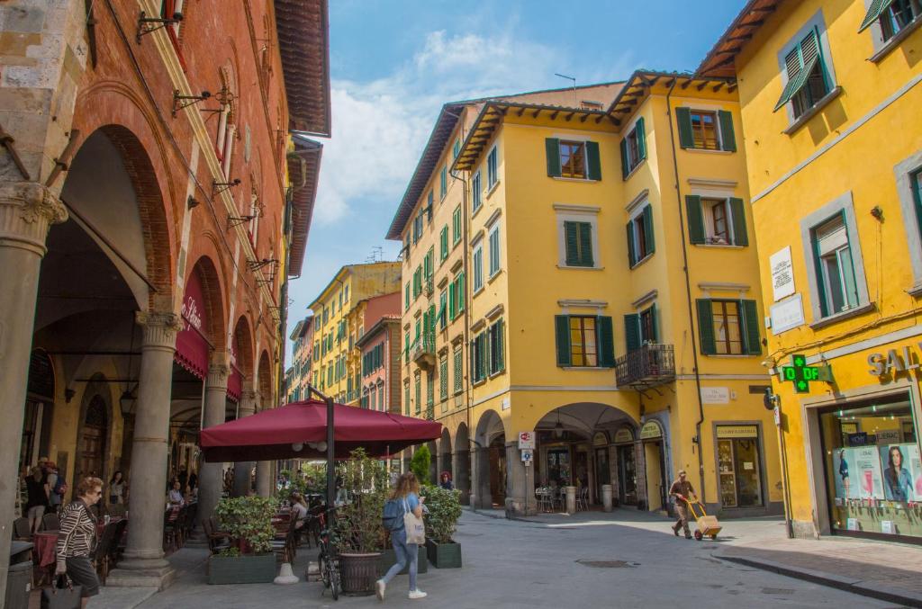 a street with yellow buildings and people walking down a street at Rinascimento Bed & Breakfast in Pisa