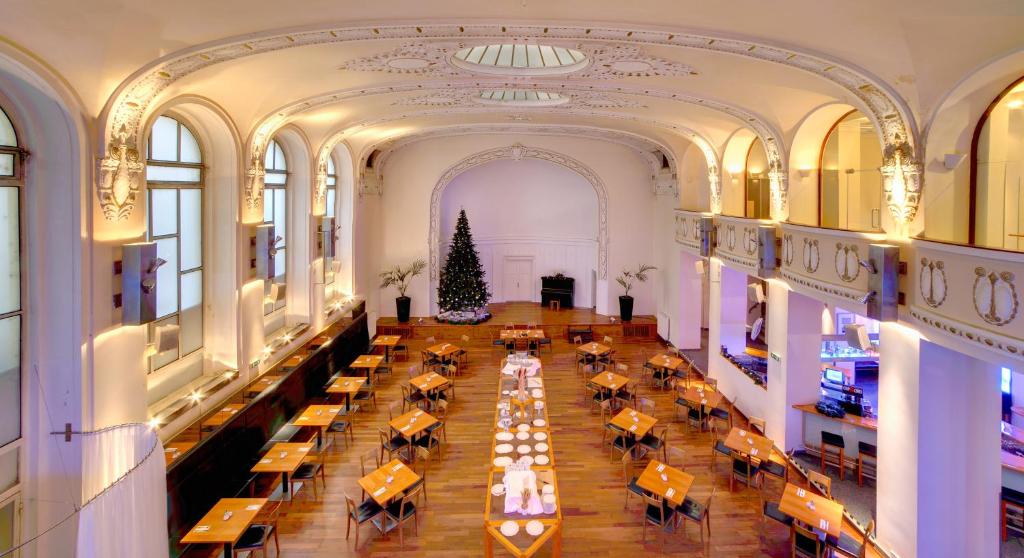 an overhead view of a dining hall with tables and a christmas tree at Theatrino Hotel in Prague