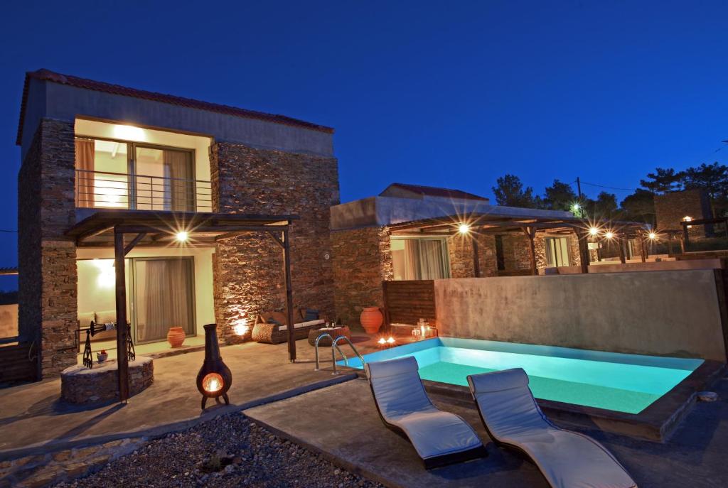 a swimming pool in front of a house at night at Gerakari Suites in Agia Pelagia Kythira