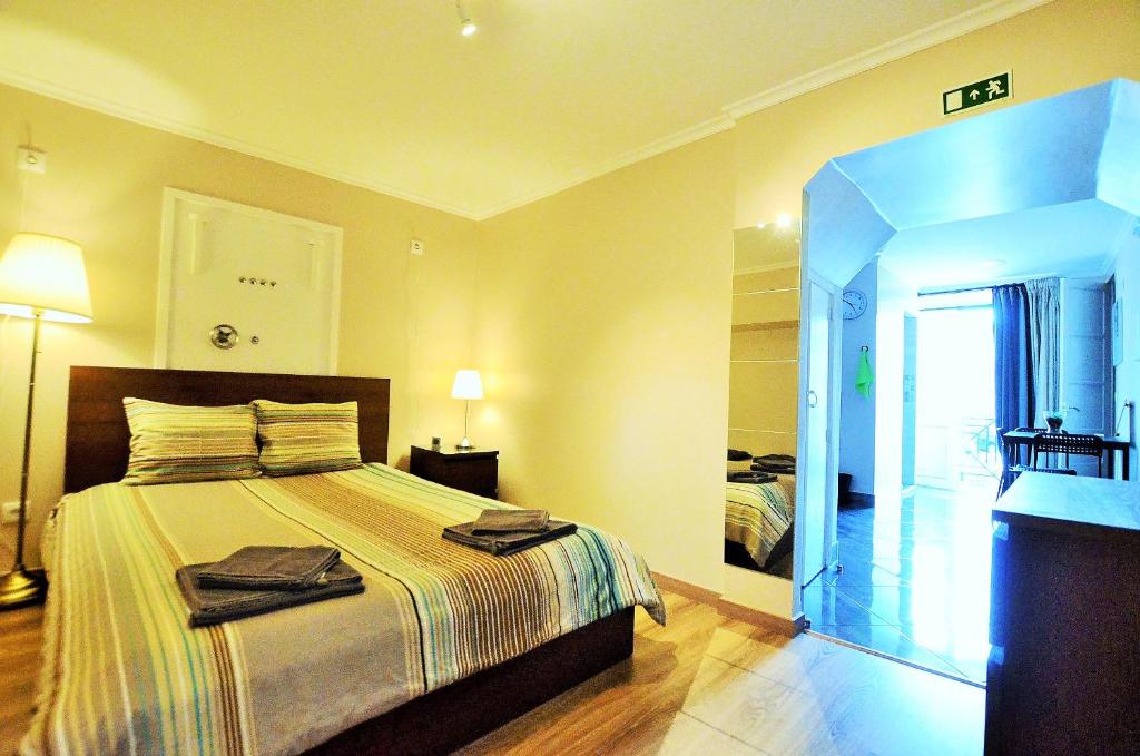 a hotel room with a bed and a television at Suites & Apartments - DP Setubal in Setúbal