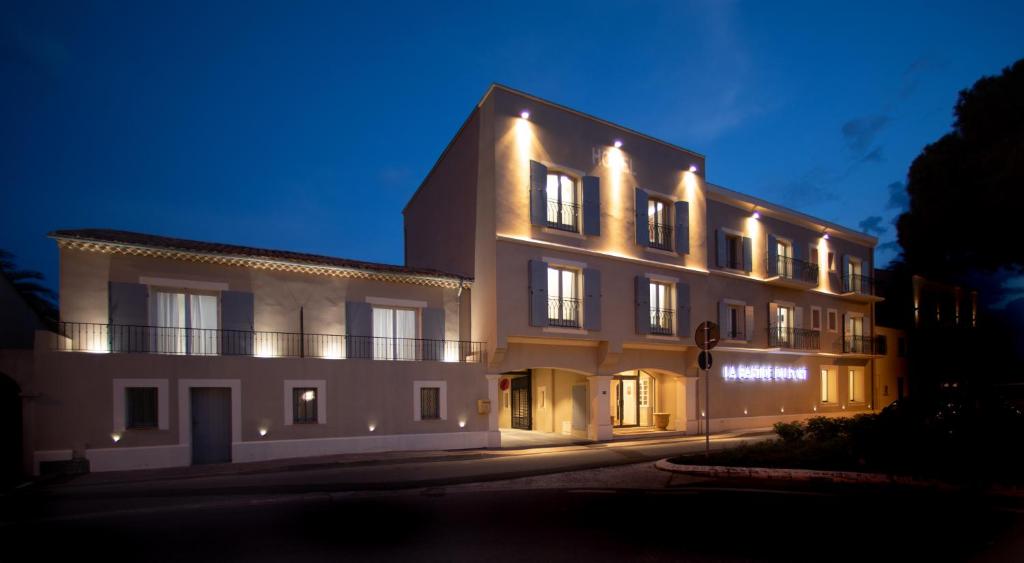 a large white building with lights on it at night at La Bastide Du Port - Hôtel de Charme in Saint-Tropez