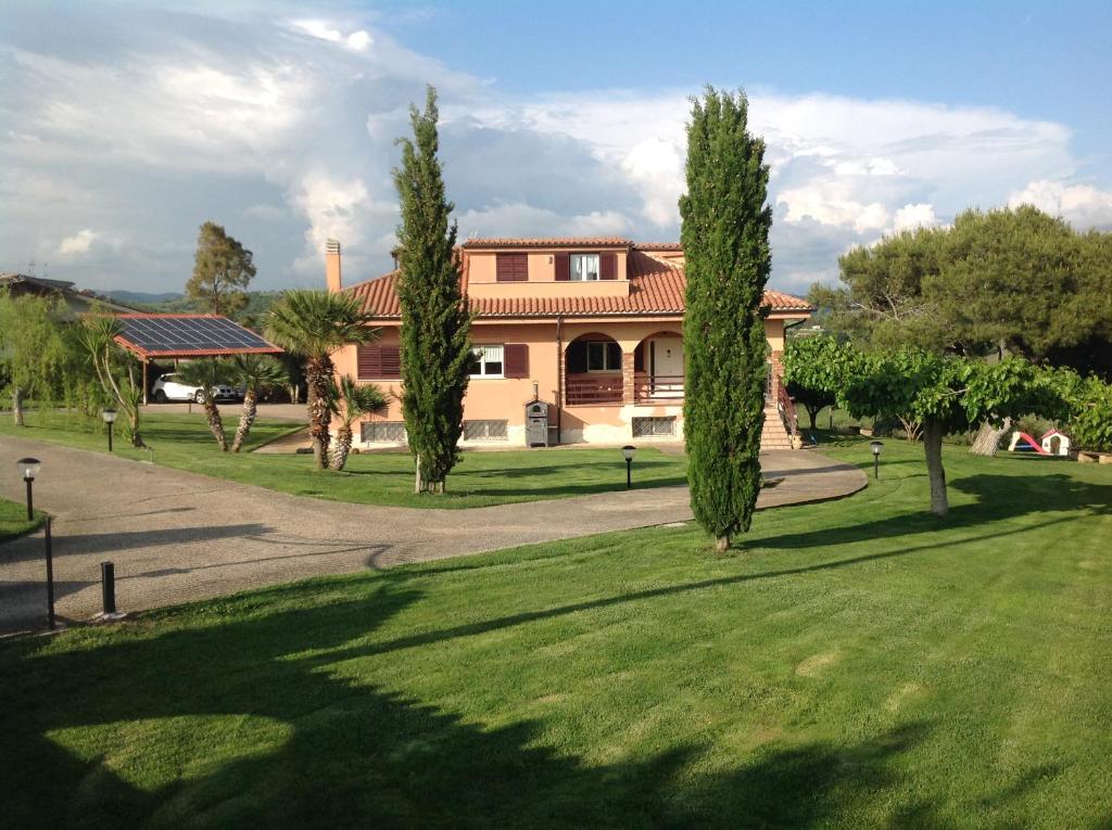 une maison avec des arbres devant une pelouse dans l'établissement Bed & Breakfast La Volpe e L'Uva, à Santa Marinella