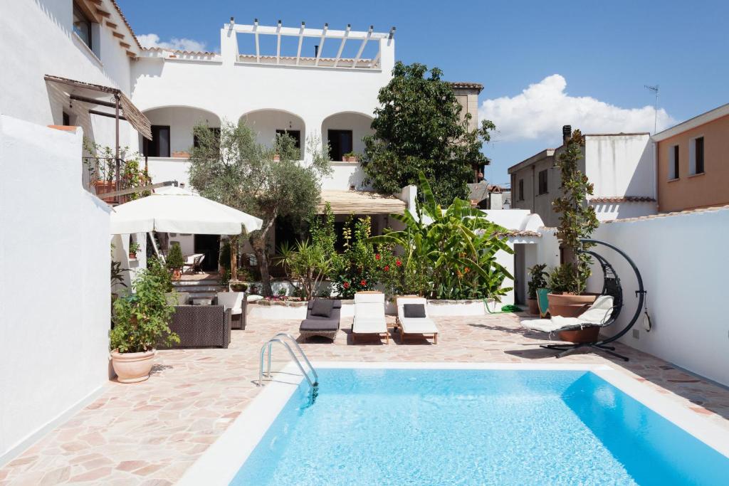 a pool in a courtyard with a house at Gulf of Orosei Luxury Mediterranean House in Irgoli