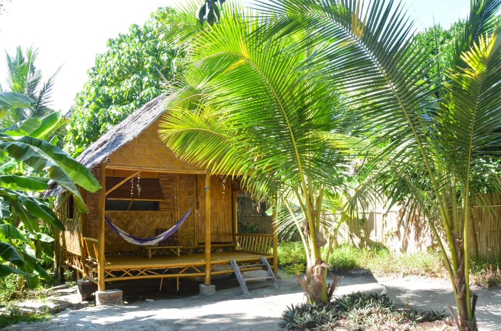 eine Hängematte vor einem Haus mit Palmen in der Unterkunft Forra Dive Resort Pattaya Beach in Ko Lipe