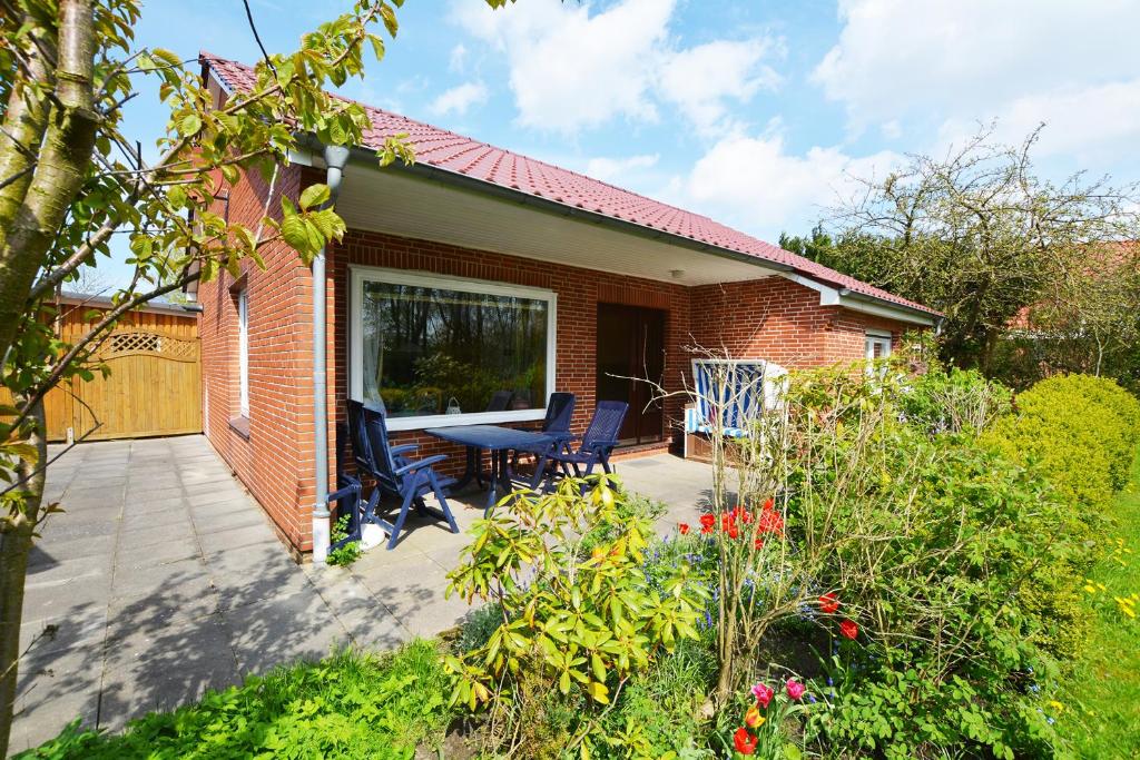een bakstenen huis met een terras met stoelen erop bij Haus Emilie in Büsum