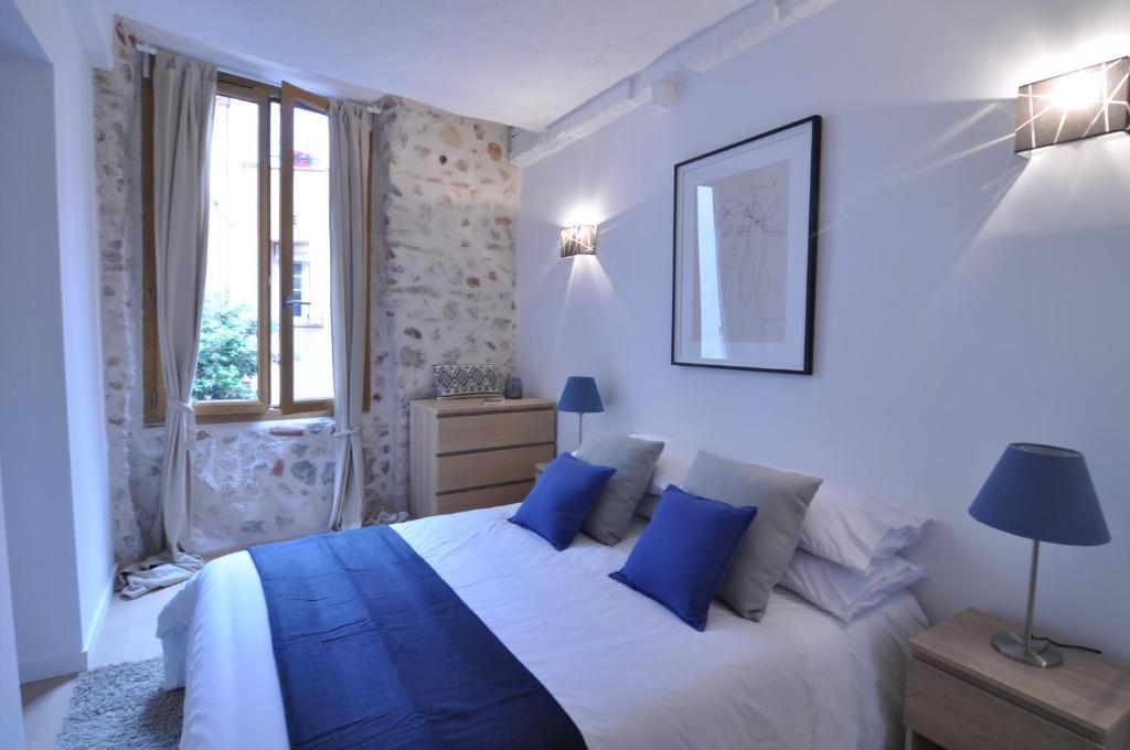 a bedroom with a large bed with blue pillows at Superb one-bedroom apartment - StayInAntibes- Picasso 1 in Antibes