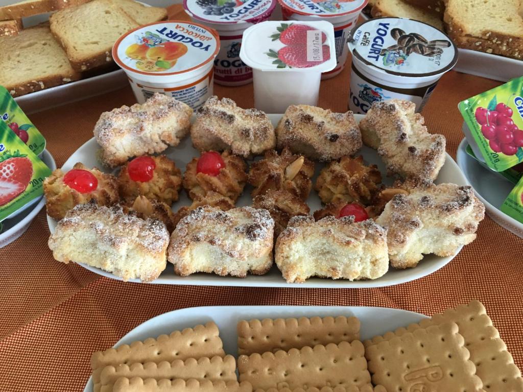 a table with a plate of food with biscuits and cakes at Daedalium in Marina di Palma