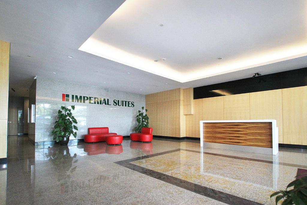 a lobby with red chairs and a sign that reads it imperial suites at Bernard Holiday Home @ Imperial Suites Kuching in Kuching