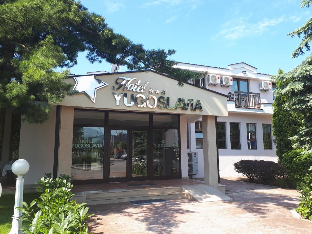 a building with a sign for a restaurant at Hotel Yugoslavia in Nikšić