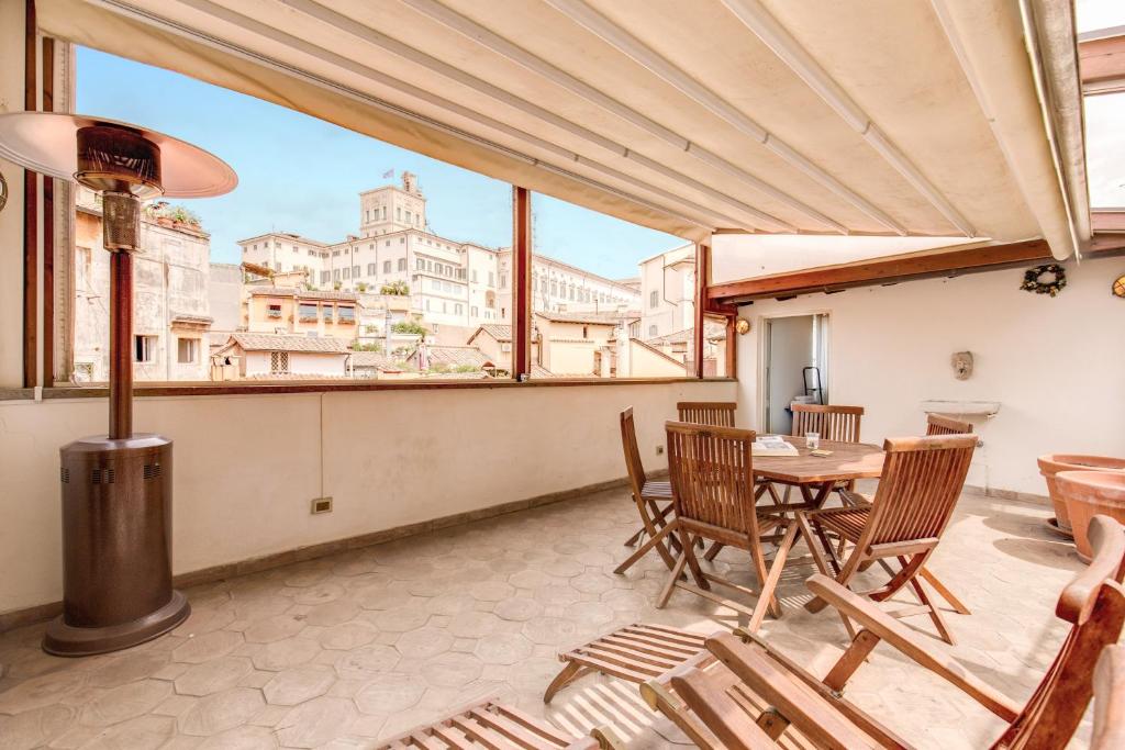 einen Balkon mit einem Tisch und Stühlen sowie Stadtblick in der Unterkunft Amazing Attic with Terrace by Trevi Fountain in Rom
