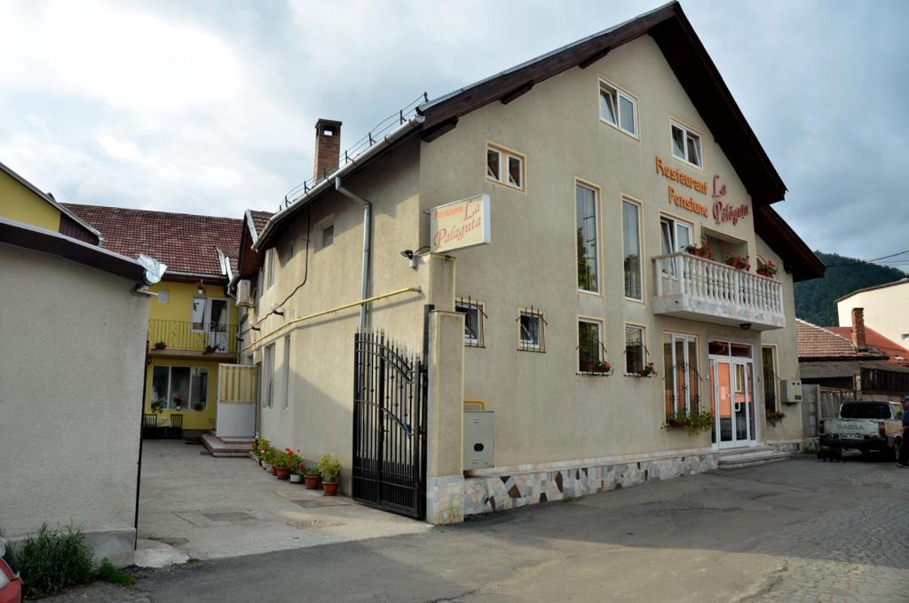 un grande edificio marrone chiaro con balcone di Pensiunea La Palaguta a Baia Mare