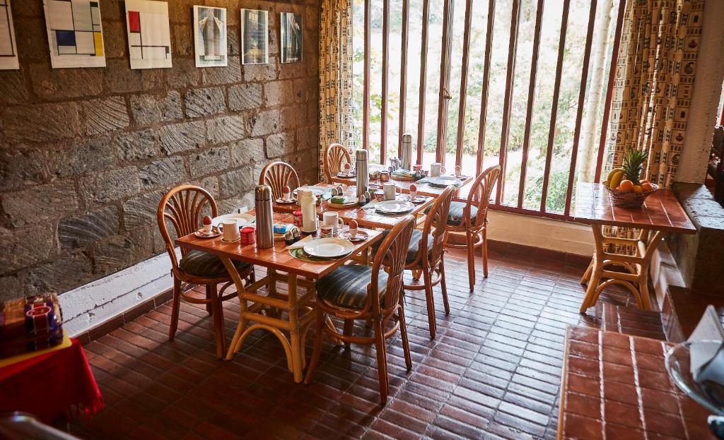 a dining room with a table and chairs and a window at Villa Rock Stop Falls Gigiri in Nairobi