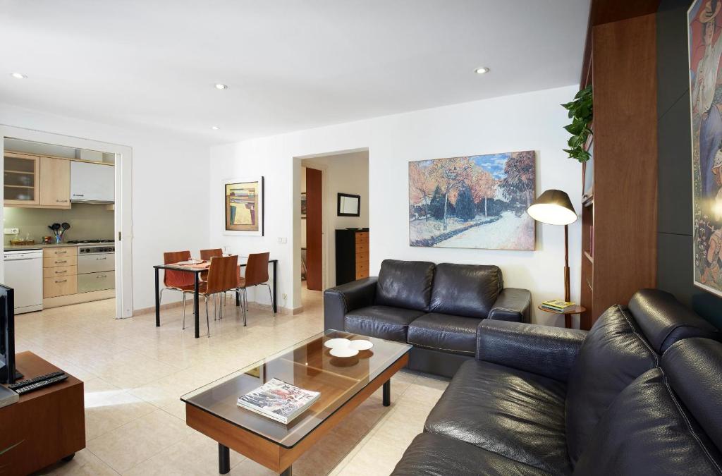 sala de estar con sofá de cuero y mesa en Apartamentos Calvet, en Barcelona