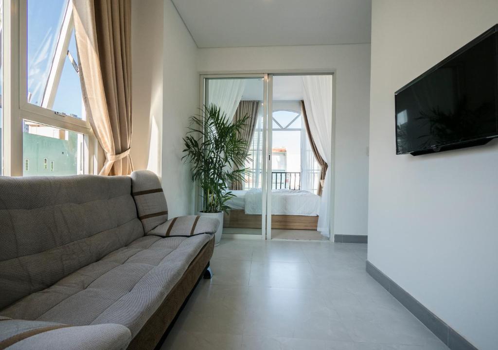 a living room with a couch and a flat screen tv at Minh Apartment in Danang
