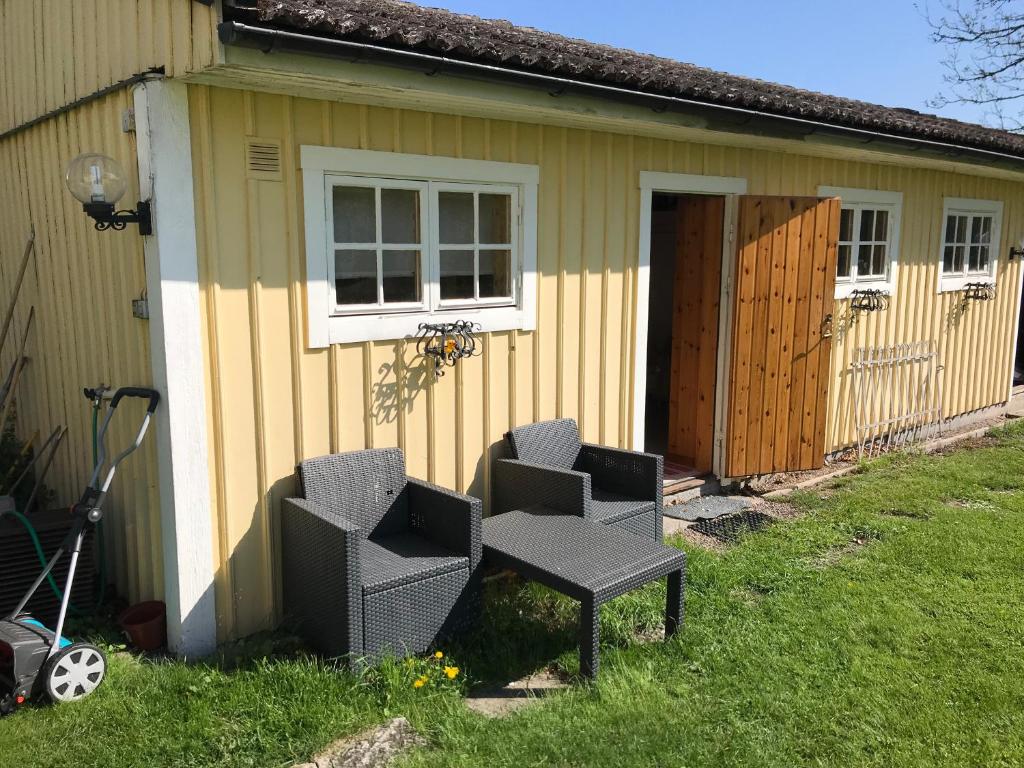 a house with a table and chairs in front of it at Gäststuga i Löfsäng Hajstorp in Töreboda