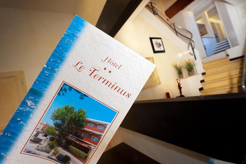 een boek bovenop een bureau bij Hotel Le Terminus in Le Lavandou