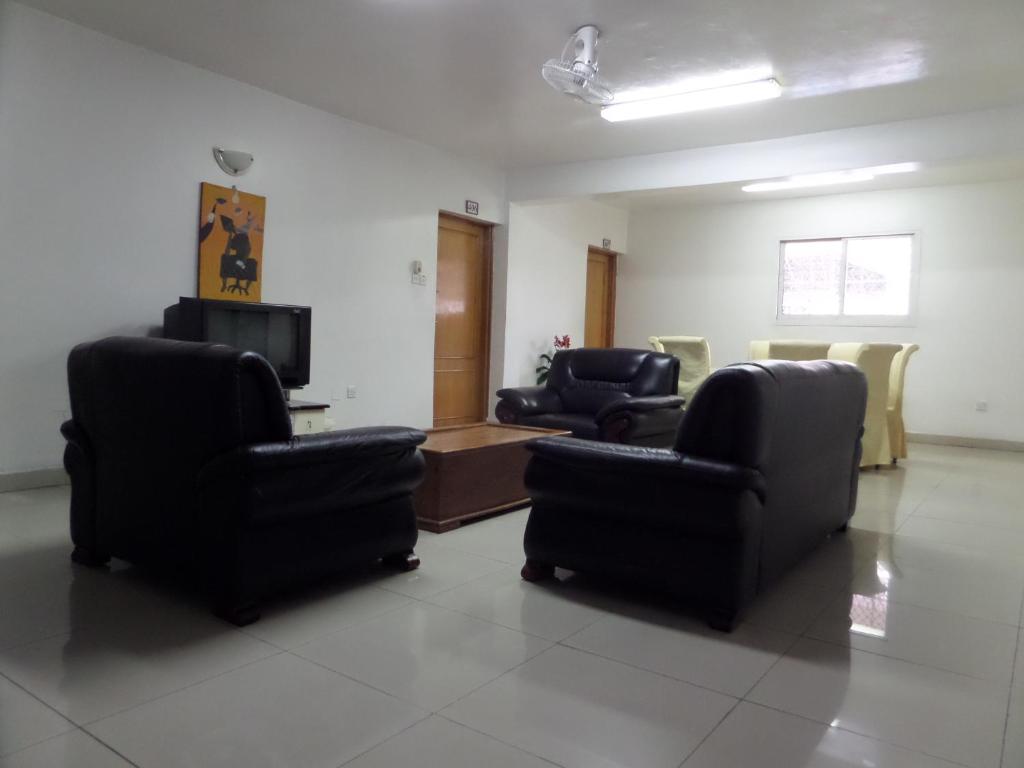 a waiting room with three chairs and a tv at Sophia Hotel in Dar es Salaam