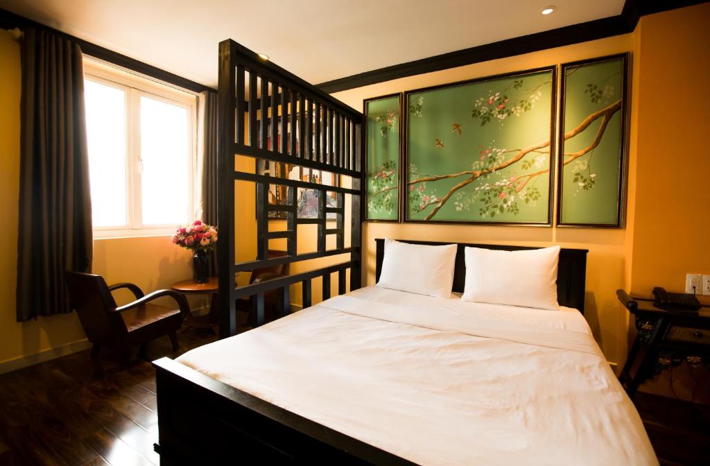 a bedroom with a bed with white sheets and a window at Ipeace Hotel - Bùi Viện Walking Street in Ho Chi Minh City
