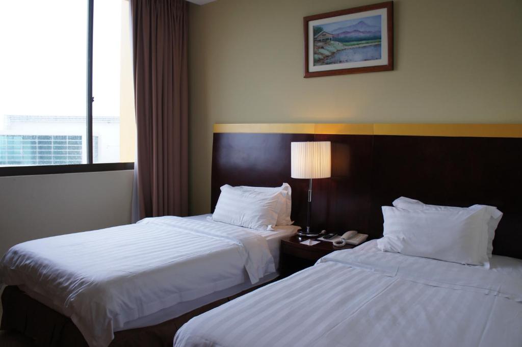 Postel nebo postele na pokoji v ubytování Gaya Centre Hotel