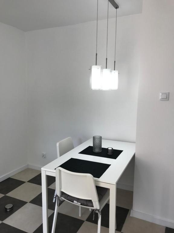ein weißes Esszimmer mit einem Tisch und einem Stuhl in der Unterkunft Apartament Matejki 7/4 in Zielona Góra