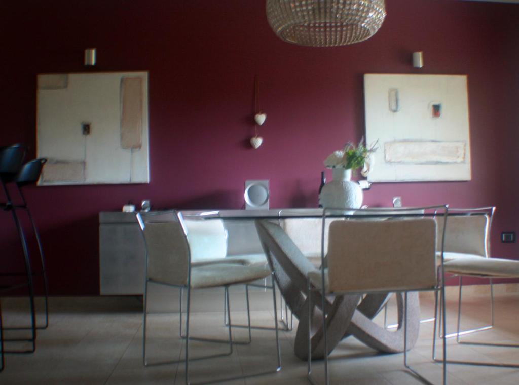 een eetkamer met een tafel en stoelen en een paarse muur bij Villa delle Rose in Giulianova