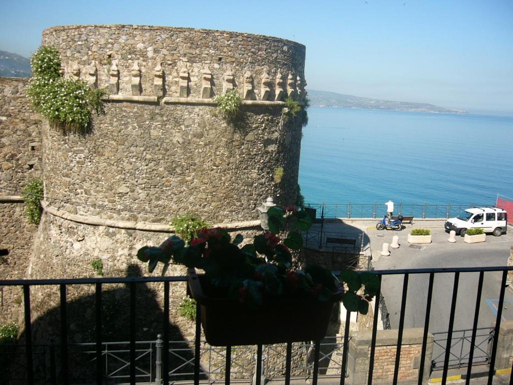 una gran pared de piedra junto al agua en Murat Guesthouse, en Pizzo