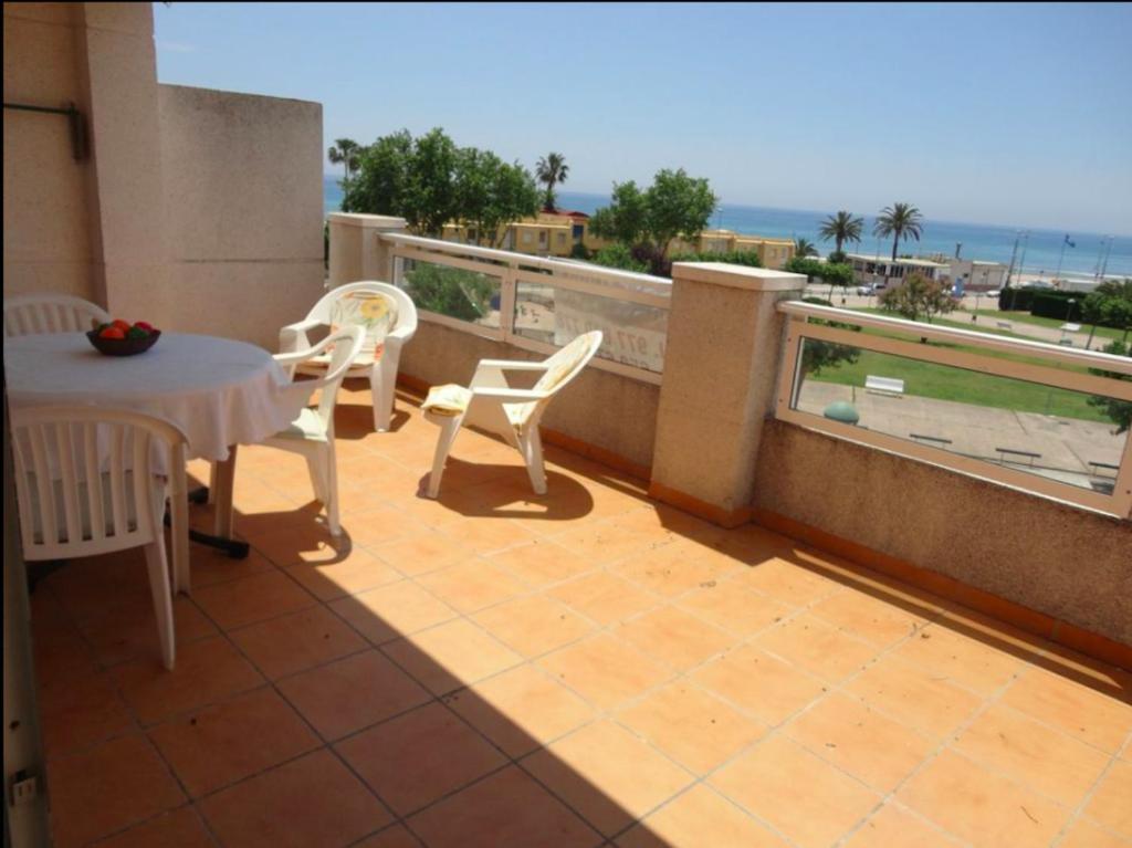 a balcony with a table and chairs and a view of the ocean at Cala Azul 304-306 Tamarit in Tamarit