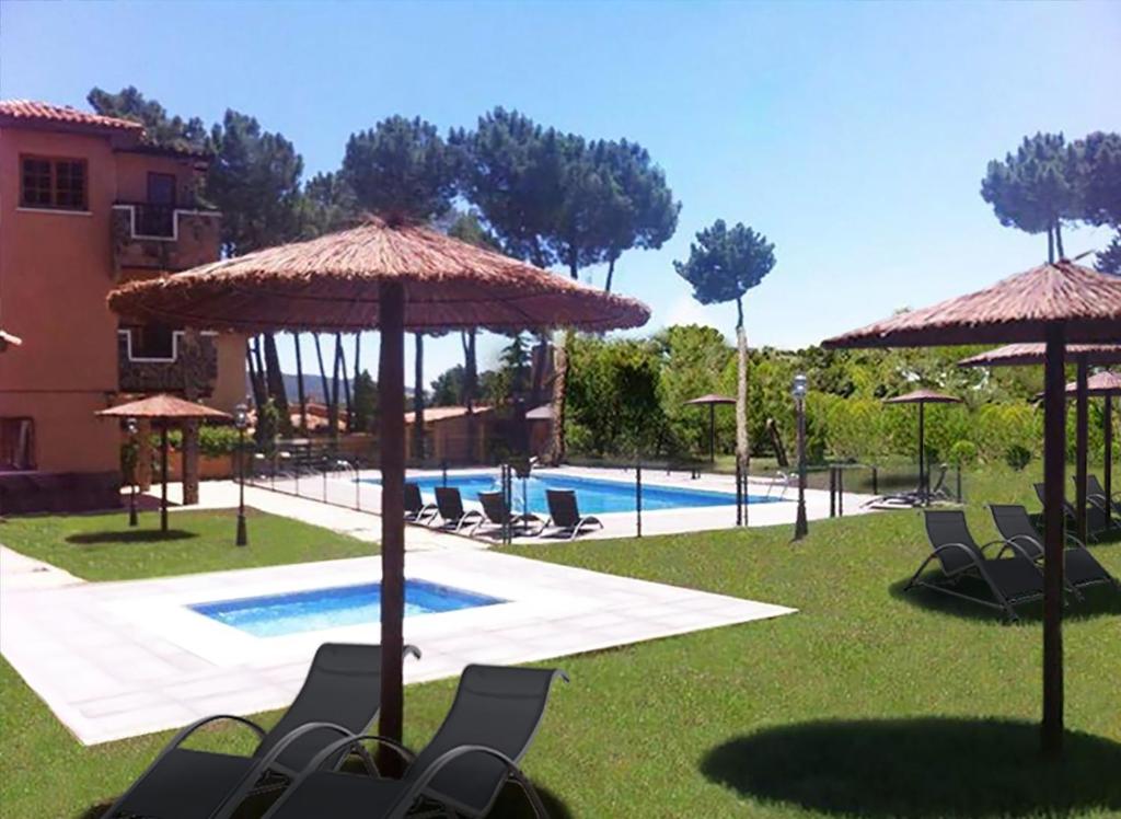 昆卡的住宿－La Villa Don Quijote，一个带椅子和遮阳伞的度假村和一个游泳池