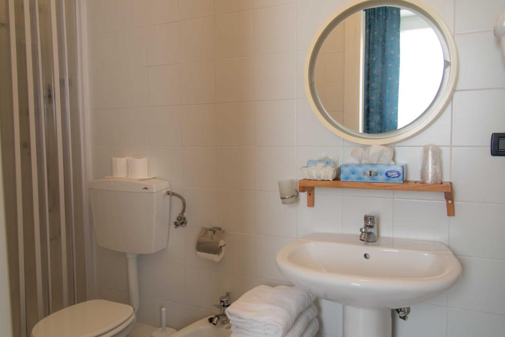 łazienka z umywalką, toaletą i lustrem w obiekcie Hotel Elisabetta w mieście Sestri Levante