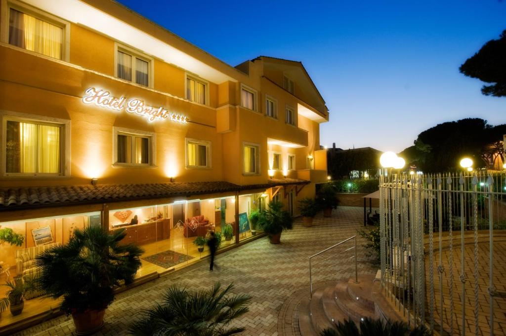 a person standing outside of a hotel at night at Hotel Bright in Rome