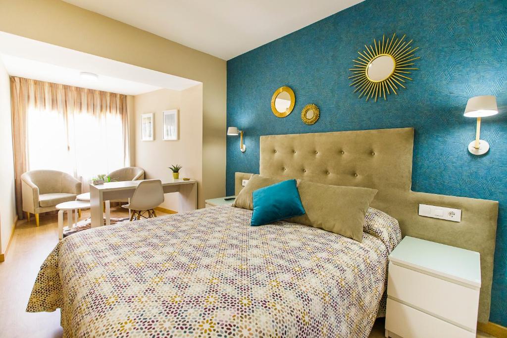 a bedroom with a bed with a blue wall at Hospedería Castilla Plaza Mayor in Ciudad-Rodrigo