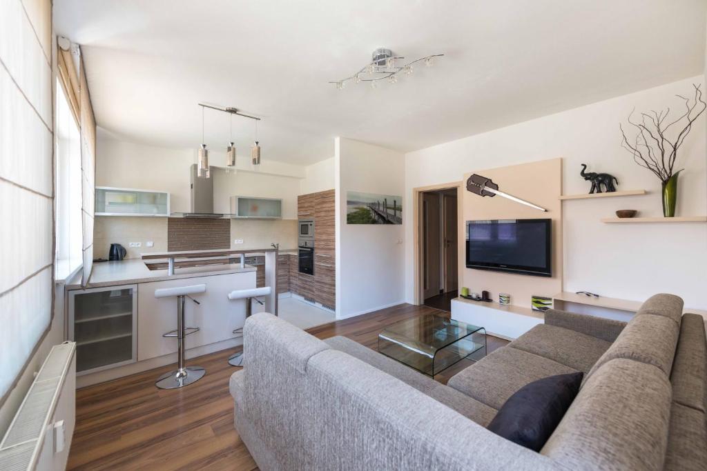 a living room with a couch and a kitchen at Apartsee U Ježíška in Pilsen