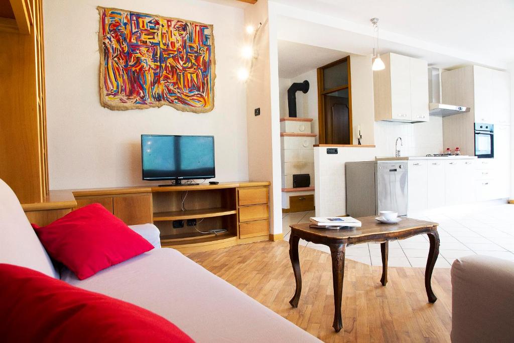 Casa Moiser في Tresenda: غرفة معيشة مع أريكة وطاولة مع تلفزيون