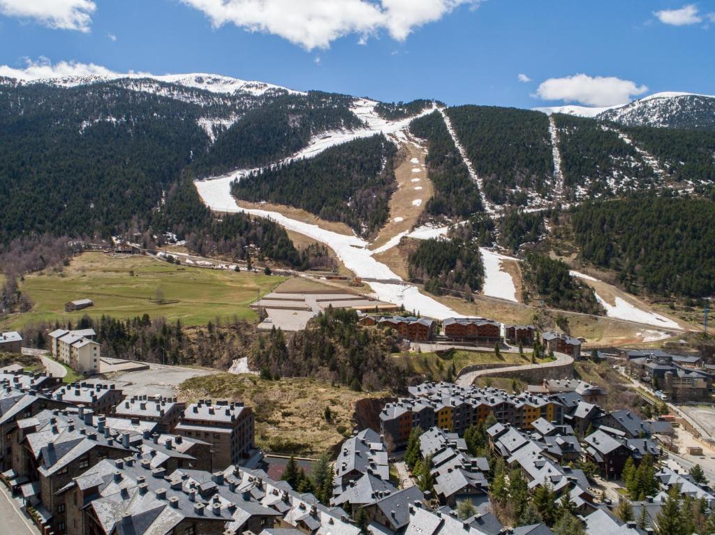 una vista aérea de una ciudad con una montaña cubierta de nieve en Apartaments Esquirol El Tarter, en El Tarter