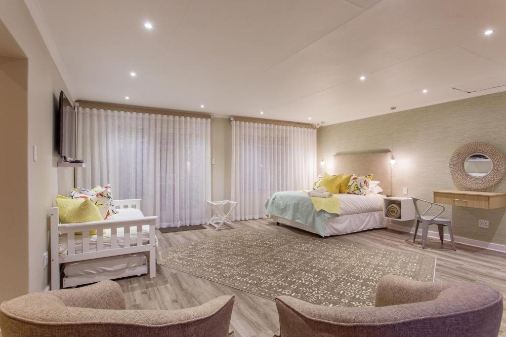a bedroom with two beds and a crib at The Aviary in Pretoria