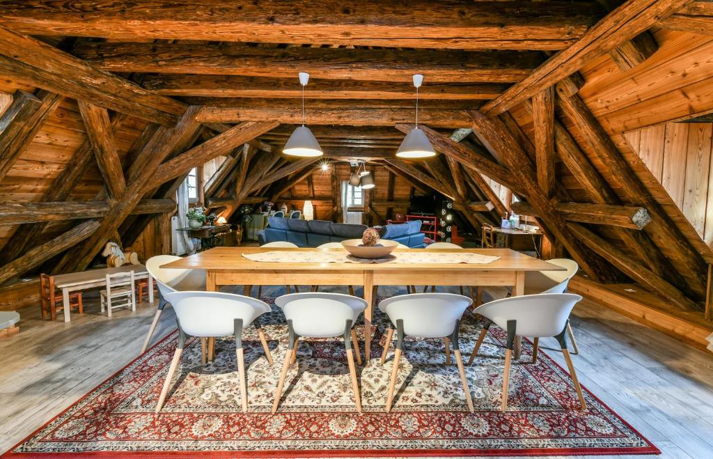 une salle à manger avec une grande table en bois et des chaises blanches dans l'établissement Porte des Pucelles, à Ribeauvillé