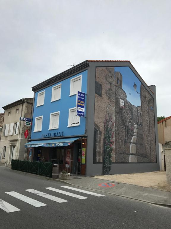 un edificio blu con un murale sul lato di Le Logis Charmant a Charmes-sur-Rhône