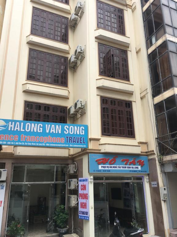 una tienda frente a un edificio con letreros. en Ho Tay Hotel en Ha Long