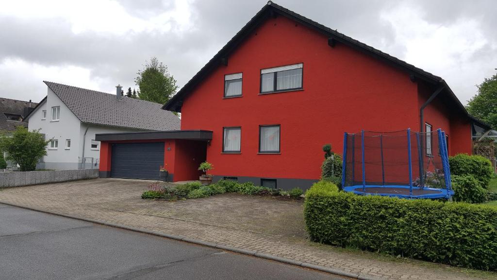 una casa rossa con un garage in un vialetto di Fewo Engelberg a Bad Dürrheim