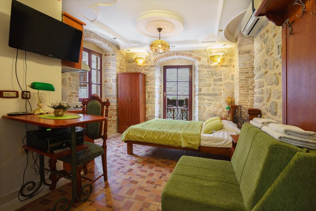 a bedroom with a bed and a desk and a tv at Apartments Wine House Old Town in Kotor