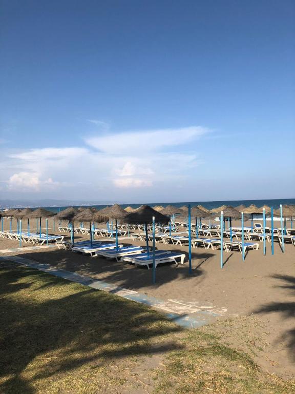 grupa stołów i parasoli na plaży w obiekcie Playamar Beach w mieście Torremolinos